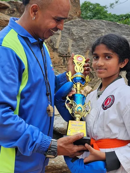 A happy student receives her trophy. We encourage our girls to be strong and fearless competitors in the sport of karate.