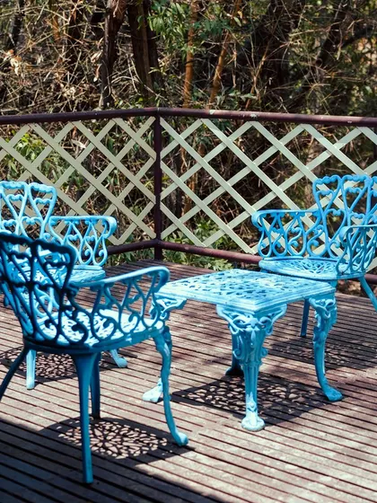 A charming blue patio set on a wooden deck, offering a picturesque spot to relax and enjoy the outdoors.