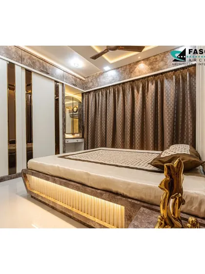 This bedroom in Bhiwandi features a unique bed with an illuminated base and a backdrop of textured wallpaper and cove lighting. The sliding wardrobe with mirrored strips enhances the sense of space and adds a modern touch.