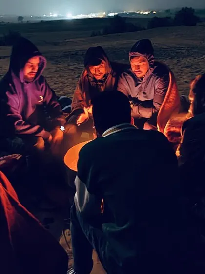 Sharing stories and warmth around a campfire in the chilly desert night. This is how we bond and create lasting memories under the starlit sky.