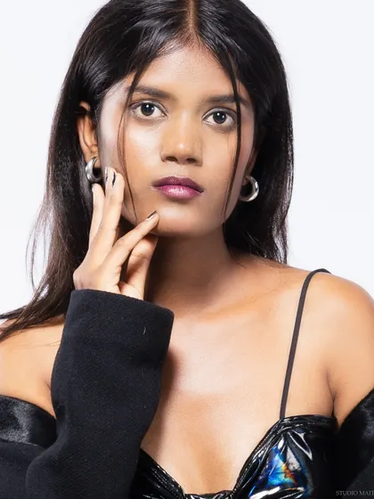 A close-up portrait of a model, focusing on her direct gaze and edgy styling.