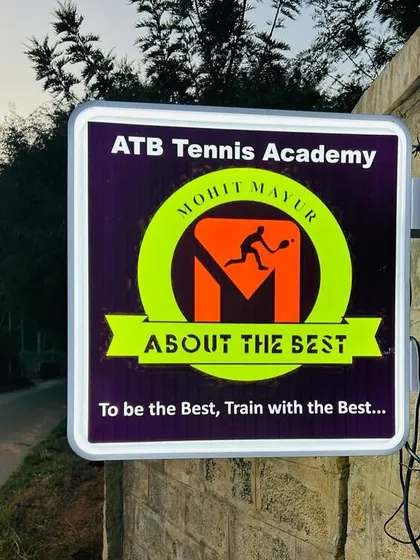 Our academy's illuminated sign at dusk. We are dedicated to tennis training day in and day out.