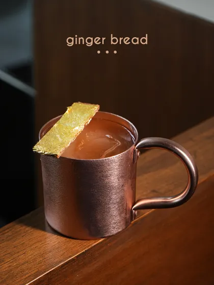 The Ginger Bread cocktail offers warmth and spice in a copper mug. This drink balances the sharp, aromatic notes of ginger with deeper, comforting flavors, creating a perfect sipper for any season.