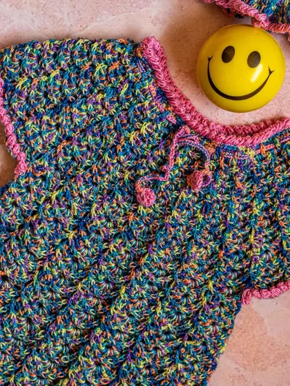 A unique, handcrafted crochet top in a vibrant multi-color yarn with pink trim. This piece showcases my ability to work with different textiles to create one-of-a-kind items.
