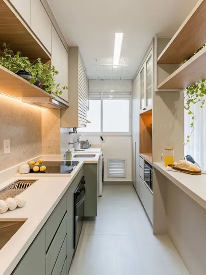 A render of a compact galley kitchen that opens into the living space. The design uses light colors and open shelving with plants to create a fresh and airy atmosphere.