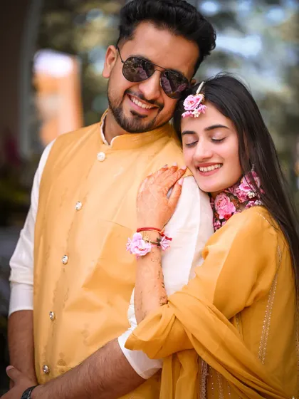 A happy, relaxed portrait of the couple, their yellow outfits perfectly matching the vibrant Haldi theme.