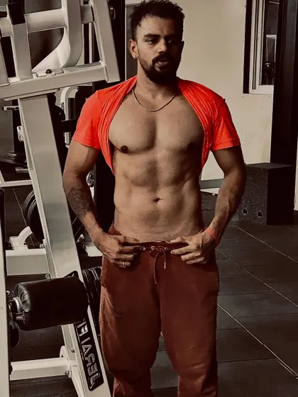Checking for ab definition after a tough workout. A visible six-pack is earned through a combination of targeted core work and a solid nutrition plan, both part of my coaching.