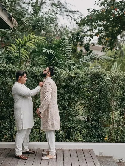 A quiet moment of the groom getting ready with the help of a friend. We document the entire process, including these moments of camaraderie and support.