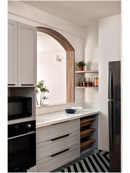 A modern, minimalist kitchen from our "Between Shades of Grey" project, featuring light grey cabinets, an arched pass-through, and open shelving.