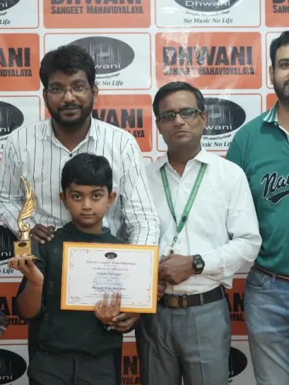 A family poses with their son and his teachers, celebrating his achievement at the annual function.