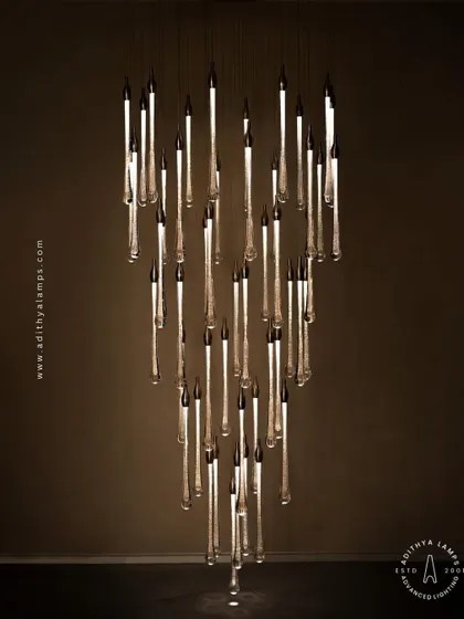 A stunning cluster of crystal teardrop pendants. Each pendant contains bubble-like inclusions that catch the light, creating a sparkling, rain-like effect. This is an elegant choice for double-height foyers or modern staircases.