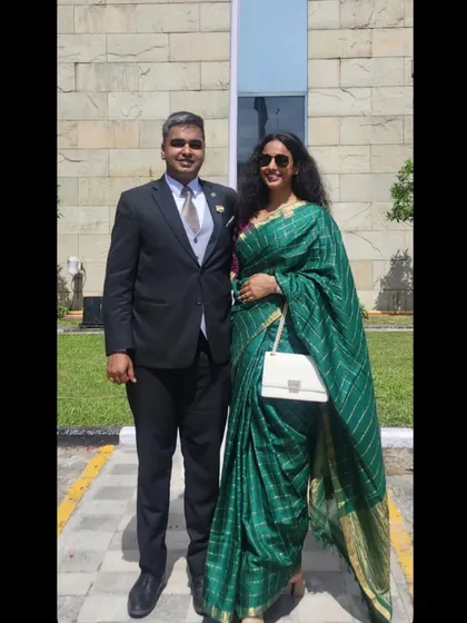 A classic look for a formal event. I chose this beautiful emerald green saree with subtle gold stripes, paired with a simple white handbag. This shows how I can create a sophisticated and timeless wedding guest style that is both graceful and eye-catching.