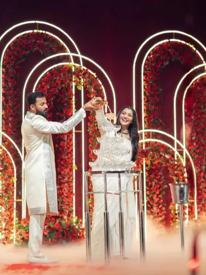 The couple pours champagne over a tower of glasses, a spectacular moment during their Sangeet celebration.