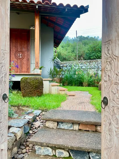 The entrance to a cottage at TARA resort, framed by intricately carved wooden doors. This detail showcases the blend of local craftsmanship and Japanese-inspired tranquility that defines the project.