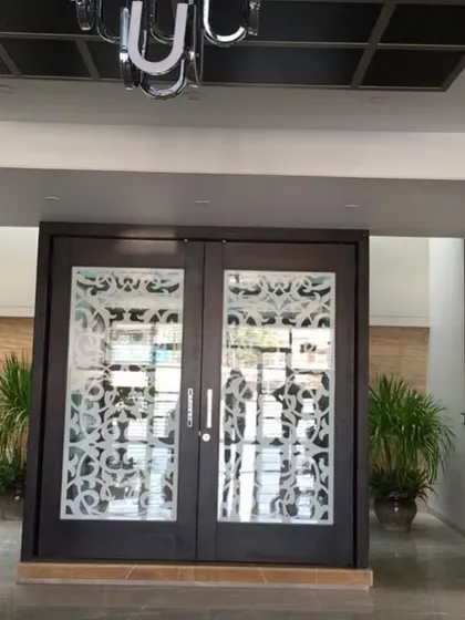 The entrance to a home I worked on, where two large potted Kentia palms frame the ornate doors, creating a grand and symmetrical welcome.