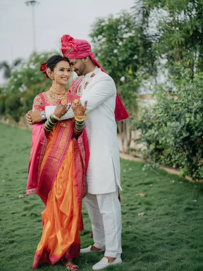 A classic, loving embrace. The vibrant colors of their Maharashtrian outfits and the green background make this a very lively portrait.