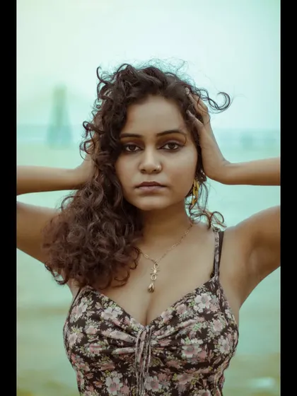 A classic modeling pose that conveys a bit of drama and intensity. The hands framing the head draw attention to the model's face and windswept hair.