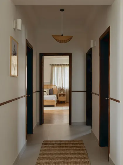 The entryway leading to the bedrooms is deliberately understated. A simple jute runner and a single pendant light guide the way, allowing the design of the rooms beyond to take center stage.