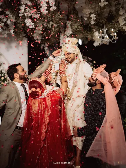 The groom is lifted by his friends during the Varmala ceremony, a fun and competitive tradition we love to capture.