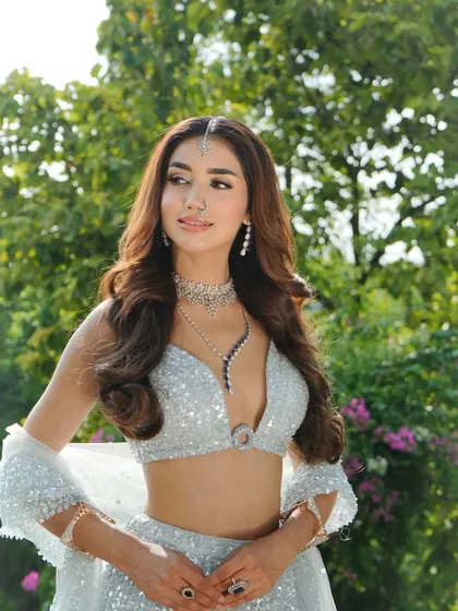A closer look at the modern bridal styling. The diamond jewelry, including a delicate maang tikka and nose ring, perfectly complements the cool tones of this sequined lehenga.