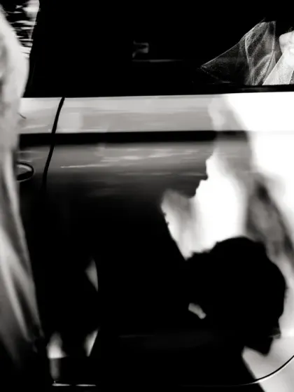 Playing with light and shadow. The bride is visible in the car, but the story is told through the dramatic shadows of people on the car door.