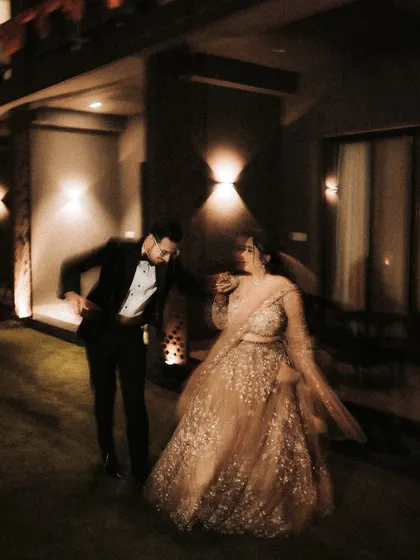 A candid, motion-blurred shot of the couple sharing a dance. The warm lighting and blurred movement convey the joy and energy of their reception party.