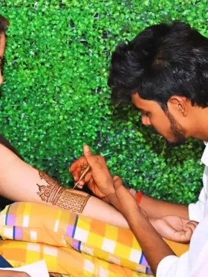Me applying mehandi for a beautiful bride against a green backdrop.