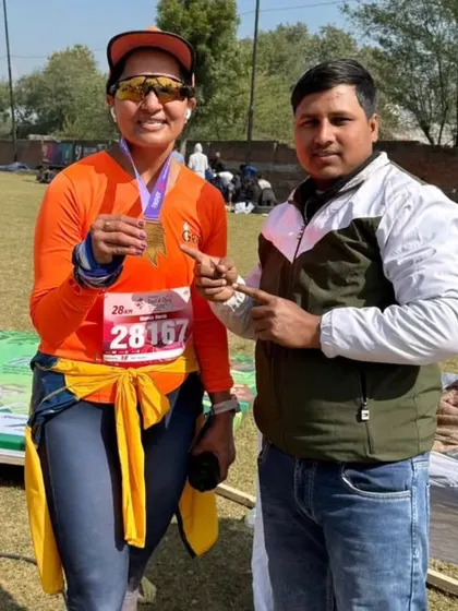 A GRR runner at the Trailathon 2025, proudly holding her finisher medal. We conquer all terrains.