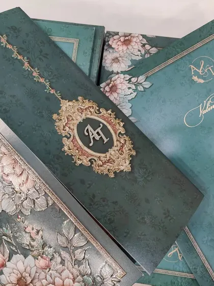 This is a full view of the emerald green floral invitation set. You can see how the custom monogram, the detailed inserts, and the outer envelope all work together to create a cohesive and luxurious suite.