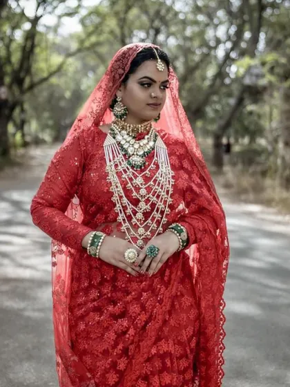 This bride looks like royalty in her red saree and layered Kundan and pearl jewellery. The seven-layer haar is a statement piece that is sure to turn heads.