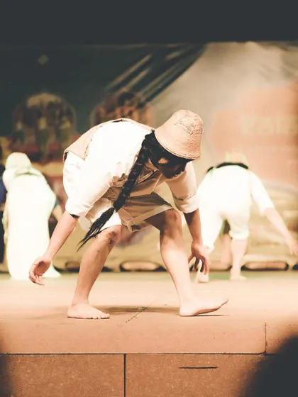 A performer in traditional attire bows on stage, captured with a warm, grainy edit. This photo showcases my experimental editing style, giving the image a timeless, film-like quality.