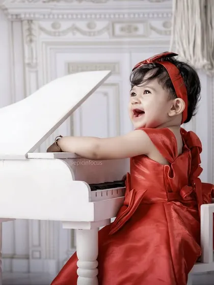 A moment of pure joy at the piano. We capture the delightful expressions as children explore the mini grand piano prop in our music-themed shoot.