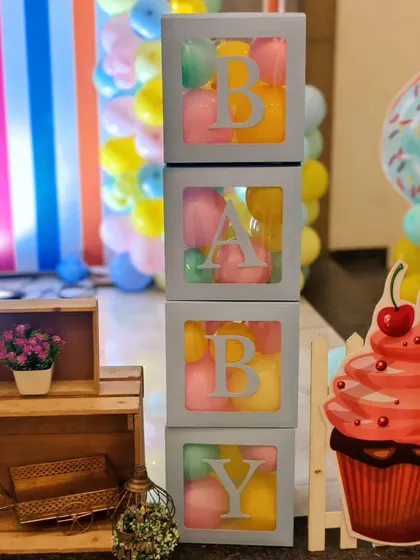 'BABY' blocks filled with pastel-colored balls, a giant cupcake cutout, and a donut prop are just some of the sweet details from this Candyland party.