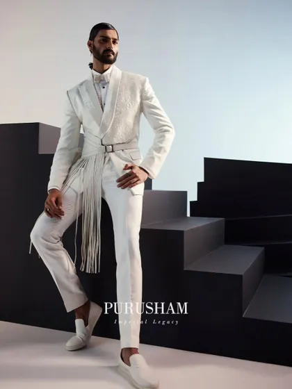 White is a powerful statement. For this ensemble, I combined a sharply tailored jacket with a dramatic fringed belt, creating a fusion look that is both classic and contemporary. It is a piece for the man who is not afraid to redefine tradition.
