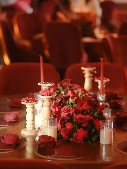 A full view of a dining table, showcasing the complete look with velvet chairs and dramatic centerpieces.