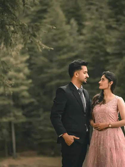 A classic, elegant portrait of the couple in formal wear against a moody forest backdrop.