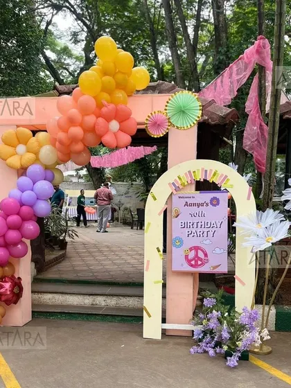 A bright and cheerful entrance for a 10th birthday party. The floral-themed balloon arch in shades of orange, yellow, and purple creates a welcoming and festive atmosphere for a fun-filled celebration.