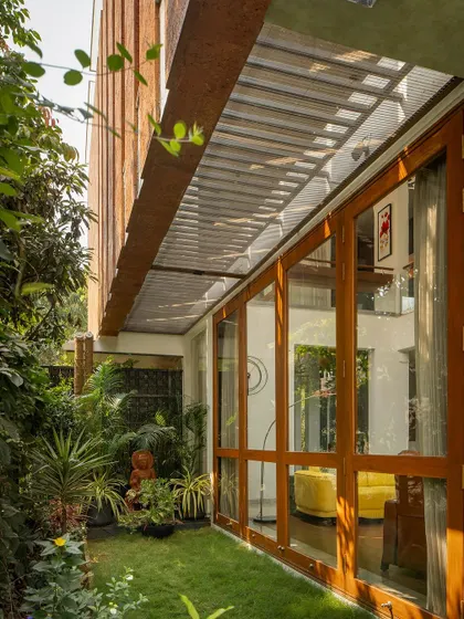 A view of the garden alongside the living pavilion. The large glass doors can be fully opened, erasing the boundary between the interior and the lush exterior.