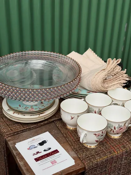 A collection of elegant tableware, including teacups, plates, and linens, prepared for our workshop. We teach you how to layer textures and patterns to create a cohesive and visually appealing tablescape.