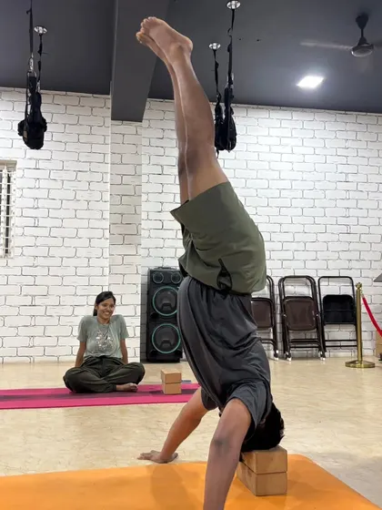 A student practices a supported headstand using blocks, a safe way to build the strength and confidence needed for inversions.