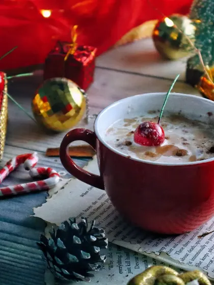 Another angle of the Christmas coffee scene, focusing on the red mug and festive props. The composition feels cozy and full of holiday cheer.