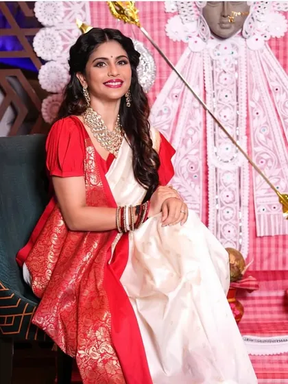 This seated portrait captures the elegance of the complete Bengali look, with makeup and hair styled to match the celebratory mood.