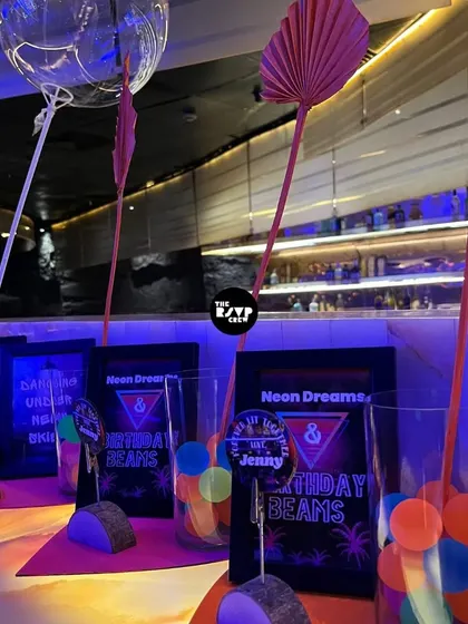 'Neon Dreams' and 'Birthday Beams'. Themed signs and glowing balls in glasses served as cool, on-theme table decor.