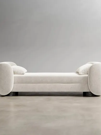The Divan, a piece of furniture all its own. It can serve as a daybed, a settee, or a chaise lounge, with a timeless bouclé fabric upholstery that gives it a rich, loopy texture.
