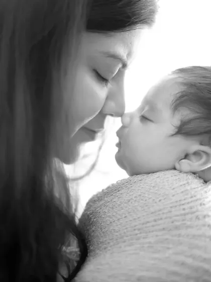 An intimate, high-contrast black and white photo capturing a tender moment between mother and child. These close-up shots are perfect for preserving the deep connection of the early days.