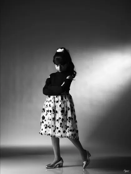 A playful yet poised black and white portrait. This shot captures a moment of quiet confidence, showing a different side of the young actress's personality during her studio session.