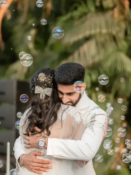 A heartfelt embrace surrounded by floating bubbles. This magical moment captures the pure emotion and dreamy atmosphere of their wedding day.
