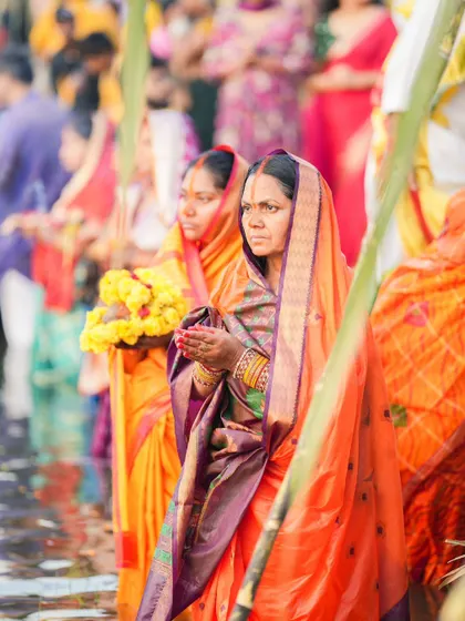 A devotee stands in the water with folded hands during Chhath Puja. This ancient festival involves offering prayers to the Sun God for life and prosperity.