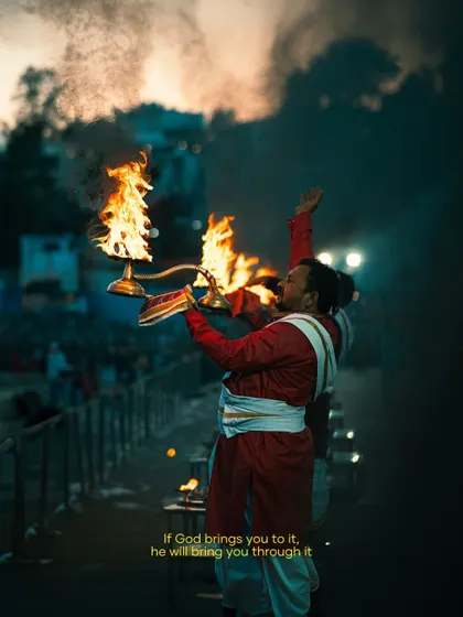 A priest performing the evening Ganga Aarti in Rishikesh. The dramatic lighting from the fire and the powerful pose make this a captivating and spiritual photograph.