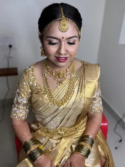Another angle of this classic Muhurtham look, highlighting the traditional jewelry and the neat, polished bridal bun hairstyle.